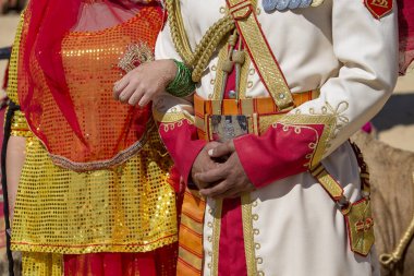 Hint düğünü için süslenmiş bir erkek ve kadının elleri, yaklaşın. Geleneksel Rajasthani kıyafeti giyen kadın ve erkek Jaisalmer, Hindistan 'daki Çöl Festivali' ne katıldılar.