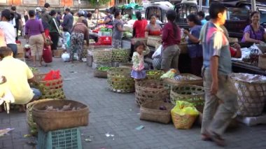 UBUD, BALI, INDONEZYA - 27 Nisan 2019: Endonezyalı fakir insanlar, Endonezya 'nın Bali adasındaki Ubud köyündeki sabah pazarında sağlıklı yiyecek satıyor ve satın alıyorlar. Sabah meyve ve sebze pazarı