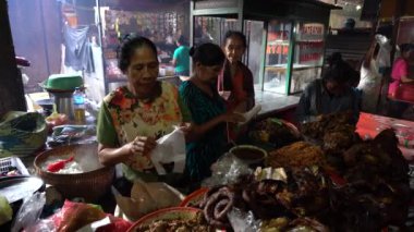 UBUD, BALI, INDONEZYA - 27 Nisan 2019: Endonezyalı fakir insanlar, Endonezya 'nın Bali adasındaki Ubud köyündeki sabah pazarında sağlıklı yiyecek satıyor ve satın alıyorlar. Sabah meyve ve sebze pazarı