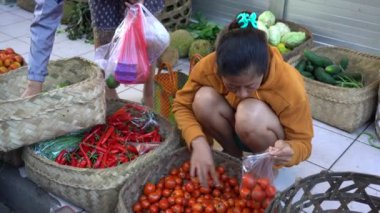 UBUD, BALI, INDONEZYA - 27 Nisan 2019: Endonezyalı fakir insanlar, Endonezya 'nın Bali adasındaki Ubud köyündeki sabah pazarında sağlıklı yiyecek satıyor ve satın alıyorlar. Sabah meyve ve sebze pazarı