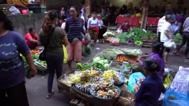 UBUD, BALI, INDONEZYA - 27 Nisan 2019: Endonezyalı fakir insanlar, Endonezya 'nın Bali adasındaki Ubud köyündeki sabah pazarında sağlıklı yiyecek satıyor ve satın alıyorlar. Sabah meyve ve sebze pazarı