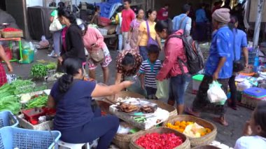 UBUD, BALI, INDONEZYA - 27 Nisan 2019: Endonezyalı fakir insanlar, Endonezya 'nın Bali adasındaki Ubud köyündeki sabah pazarında sağlıklı yiyecek satıyor ve satın alıyorlar. Sabah meyve ve sebze pazarı