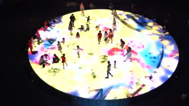 SINGAPORE CITY, SINGAPORE - MARCH 29, 2019: Large screen augmented reality experience on the floor. Children playing on Digital Light Canvas at Marina Bay Sands mall in Singapore