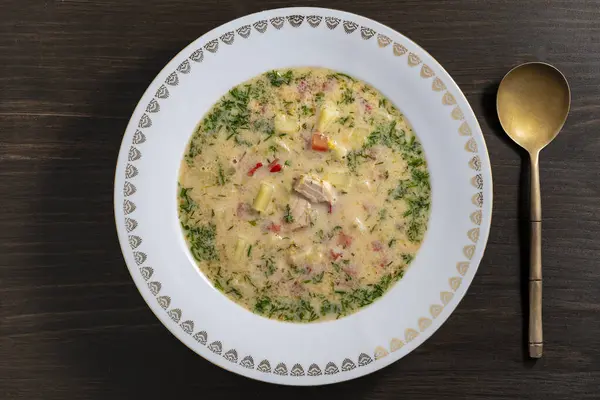 ジャガイモ ニンジン ブロッコリー コショウ タマネギを木製のテーブルのセラミックプレートにスープ クローズアップ トップビュー おいしい夕食はサーモンの魚スープで構成されています — ストック写真