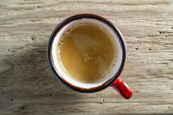 トップビュー 朝の木のテーブルの背景にエスプレッソコーヒーの赤いカップ 閉じる — ストック写真