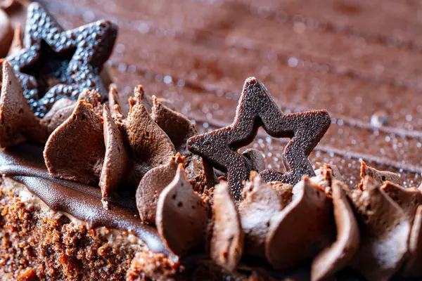 Piece of chocolate cake with star and icing, close up