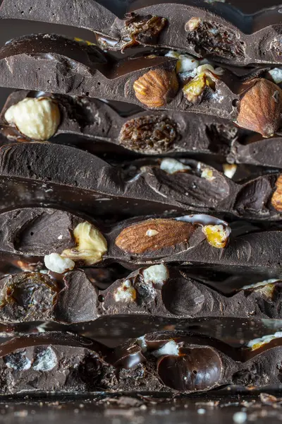 Pedaços Chocolate Escuro Com Laranja Cristalizada Passas Amêndoas Avelãs Perto — Fotografia de Stock