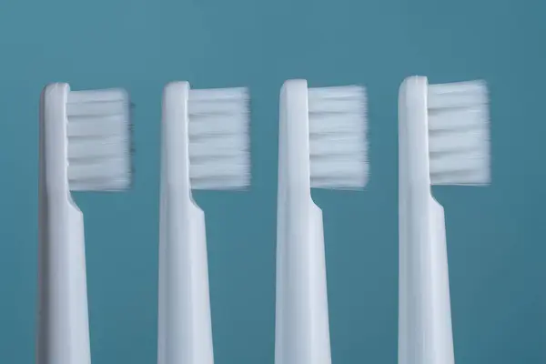 青い背景に4つの白いプラスチック歯ブラシ クローズアップ ストック写真