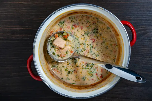 木のテーブルの上に梯子が付いているソースパンでクリームの魚のスープを左折して下さい 上の眺め ストック写真