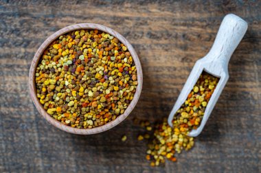 Tahta arka planda sağlıklı arı poleni tanecikleri, yakın plan, üst görünüm