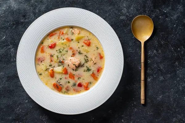 ジャガイモ ニンジン トマト コショウ タマネギを黒い背景に白い陶器板にスープ クローズアップ トップビュー おいしい夕食はサーモンの魚スープで構成されています — ストック写真