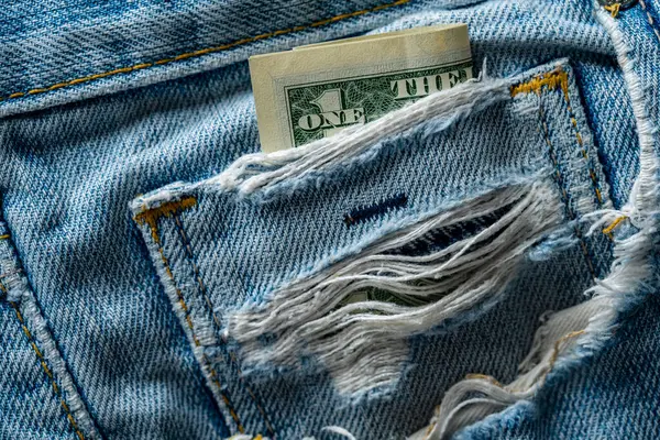 Ein Dollar Einer Aufgerissenen Alten Jeanstasche Aus Nächster Nähe Das lizenzfreie Stockbilder