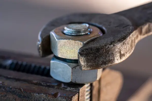 렌치와 바이스를 사용하여 너트를 풀어줍니다 볼트에서 너트를 제거하기 오래된 스패너 로열티 프리 스톡 사진