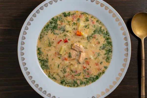ジャガイモ ニンジン ブロッコリー コショウ タマネギを木製のテーブルのセラミックプレートにスープ クローズアップ トップビュー おいしい夕食はサーモンの魚スープで構成されています ロイヤリティフリーのストック写真