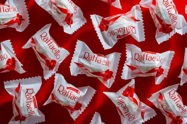 キエフ ウクライナ 2024年3月29日 イタリアのチョコレート フェレロ スペアが赤い背景で作ったフェレロ ラファエロのプレミアムスイーツの美味しさ ラファエロキャンディーは球形のココナッツアーモンド菓子です ストックフォト