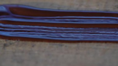 Sanatçı bir yüzeyi fırça kullanarak, yakın plan, yenileme ve yaratıcılık kavramı kullanarak kahverengi boyayla boyuyor.