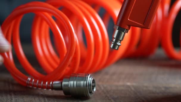 工人连接橙色的空气软管到空气吹气枪通过软管耦合 螺旋软管 用于向仪器提供气压和在远离主基地的地方工作的可能性 — 图库视频影像