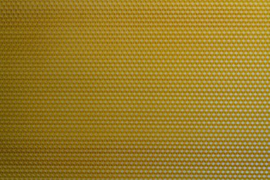 Bal dolu bir arı kovanından alınan balmumu bal peteğinin arka plan dokusu ve şablonu. Voshchina bal peteği yapımında yapay bir temel, hücrelerin balmumu tabakası