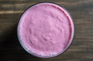 Ahududulu muzlu smoothie ahşap bir masanın üzerinde, yakın plan, üst manzara
