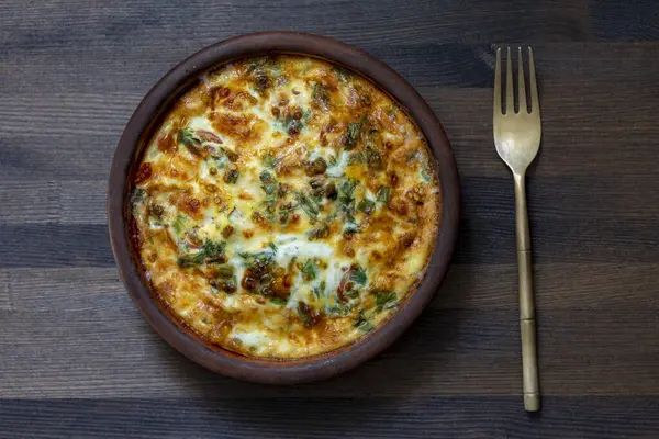野菜のフリタタとセラミックボウル シンプルな食べ物 木のテーブルに卵 コショウ タマネギ グリーン チーズが入ったフリタタ イタリアンエッグオムレツ ストックフォト