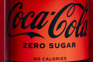 Kyiv, Ukrayna - 09 Mayıs 2024: Kırmızı arkaplanda bir şişe Sıfır Coca-Cola etiketi ve marka. Coca-Cola dünyadaki en popüler soda ürünlerinden biridir.