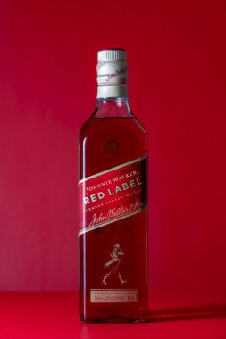 Kyiv, Ukrayna - 09 Mayıs 2024: Johnnie Walker şişesi, dünyanın en yaygın karışık viski markası. Kırmızı arka planda Johnny Walker viski, yakın plan.