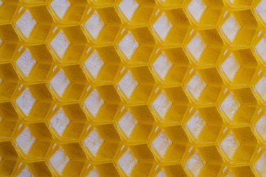 Bal dolu bir arı kovanından alınan balmumu bal peteğinin arka plan dokusu ve şablonu. Voshchina bal peteği yapımında yapay bir temel, hücrelerin balmumu tabakası