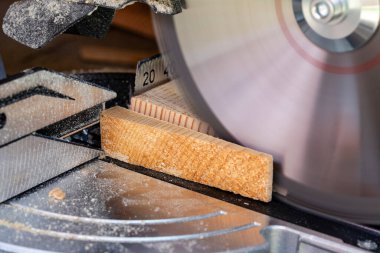 Tahta bir tahtanın kenarını kesmek için testere bıçağı, yakın çekim. Bir atölyede dairesel testere üzerinde çalışıyorum.