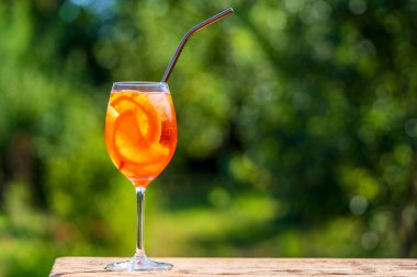 Aperol spritz kokteyli ve şarap kadehi, doğal bir arka plan. Klasik İtalyan aperatifi aperatif portakal ve buz karışımı. Yaklaş, kopyalama alanı. Yaz güneşli ferahlatıcı içecek