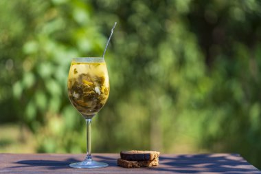 Doğa arka planında şarap kadehinde yeşil kuş çorbası, yakın plan, kopyalama alanı. Çorba çorbadan yapılır, kızılağaç yaprakları, ıspanak, haşlanmış yumurta, patates