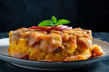 Geleneksel dilimlenmiş şeftali, bal ve nane aromalı meyveli turta, yakın çekim. Tatin tartı, turta pişmeden önce meyvelerin tereyağı ve şekerle kızartıldığı bir Fransız turtası türüdür.