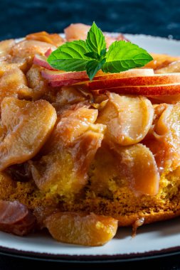 Traditional sliced fruit pie with peach, honey and mint, close up. Tarte Tatin, a type of French inside-out fruit pie in which the fruit is toasted in butter and sugar before the pie is baked clipart