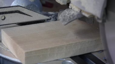 Tahta bir tahtanın kenarını kesmek için testere bıçağı, yakın çekim. Bir atölyede dairesel testere üzerinde çalışıyorum.