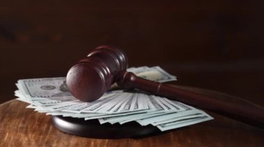 Tahta yargıç tokmağı, arka planda 100 dolarlık banknotlar olan ses panosu, kapatın. Maliye ve adalet kavramı