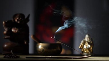 Çubuk tutacağındaki Asya tütsü çubuğu koyu arka planda dumanla yanıyor. Yaklaş. Meditasyon, yoga, kişisel gelişim ve ses terapisi kavramı
