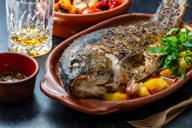 Kil tabakta baharatlı ve kızarmış sebzeli nefis sazan balığı, yakından.