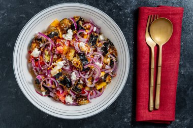 Kızarmış patlıcan, biber, soğan ve domatesli sağlıklı salata tabakta peynir, yakın plan, üst manzara.