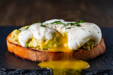 Yumurta buğulama ve yumurta sarısı. Ekmek üzeri yumurta sarısı. Avokado püresi serpiştirilmiş. Sağlıklı kahvaltı ya da öğle yemeği.