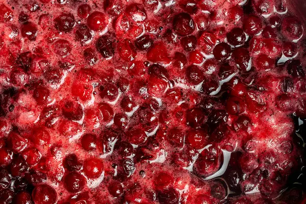 Bir reçel hazırlarken, kırmızı kızılcık bir tencerede, yakın çekim, üst manzara