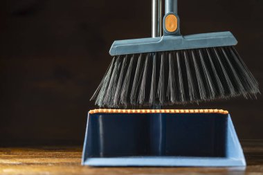 İçerideki ahşap zeminde plastik süpürge ve faraş temizliyorum.