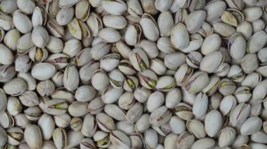 Lezzetli soyulmamış şam fıstıkları döner, üst manzara, yakın çekim. Fıstık deseni ve arka plan. Şam fıstığı çekirdekleri kabuklu fındıklar