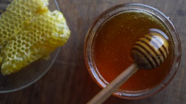 Taze bal ve ahşap ballı Dipper, yakın çekim. Sağlıklı beslenme konsepti. Cam kavanozda organik çiçek balı, üst manzara.