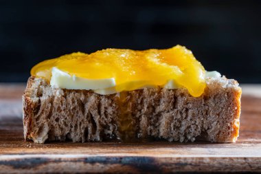 Kahvaltı için hazırlanmış tereyağlı ve ballı bir dilim ekmekten yapılmış sandviç.