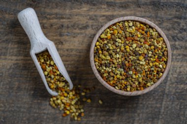 Tahta arka planda sağlıklı arı poleni ve kaşık, yakın plan, üst manzara