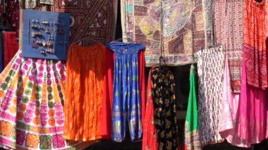 Udaipur, Rajasthan, Hindistan 'daki yerel sokak pazarında satılık renkli kıyafetlerin çeşitli ürünleri. Kapat.