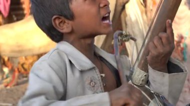 PUSHKAR, INDIA - 17, 2018: Hintli fakir çocuklar, Pushkar, Rajasthan, Hindistan yakınlarındaki Pushkar Camel Mela çölünde zamanında sitarda oynuyorlar. Hindistan 'da yoksulluk ve dilencilik