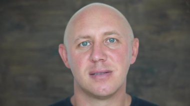 Kameraya bakan orta yaşlı, beyaz, kel bir adamın yakın çekimi. İnsanlar ve yaşam tarzı konsepti. İçerde orta yaşlı bir adamın portresi