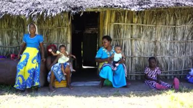 Zanzibar, Tanzanya - 13 Aralık 2019: Afrika ailesi Zanzibar, Tanzanya, Doğu Afrika 'da saman bir evin yanında oturuyor