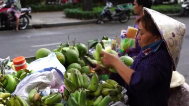 Ho Chi Minh, Vietnam - 23 Mart 2020: Vietnamlılar Ho Chi Minh, Vietnam şehir merkezindeki bir sokak gıda pazarında meyve ve sebze satıp alıyor.