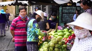 Ho Chi Minh, Vietnam - 23 Mart 2020: Vietnamlılar Ho Chi Minh, Vietnam şehir merkezindeki bir sokak gıda pazarında meyve ve sebze satıp alıyor.